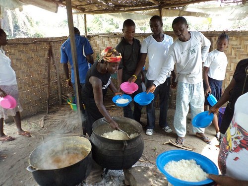 Staff members getting food from the cook