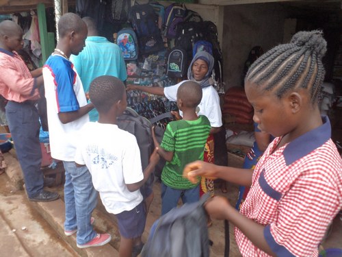 David’s sponsored kids choosing their book bags, as a parent and Vice Principal Jarvis Krangar assist in the process