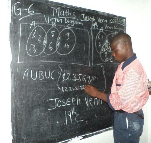 Student Jomo Peters practicing his maths on the chalkboard