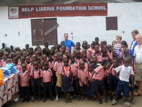 Guests posing with kids at the school