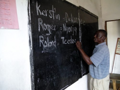 Staff member Andrew Garsuah teaching the guests their Bassa names (Photo by Lena)