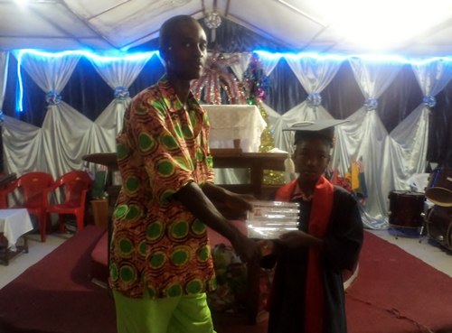 The Principal, Mr. Varney Gibson, issuing a certificate to one of the graduates