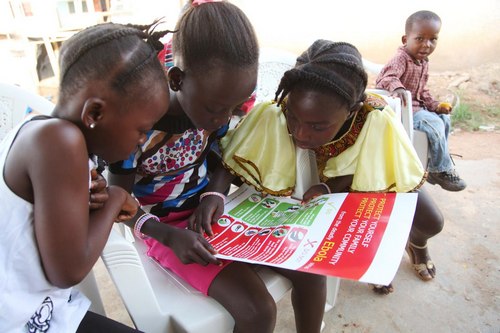 Girls reading Ebola awareness poster (Photo: UNICEF)