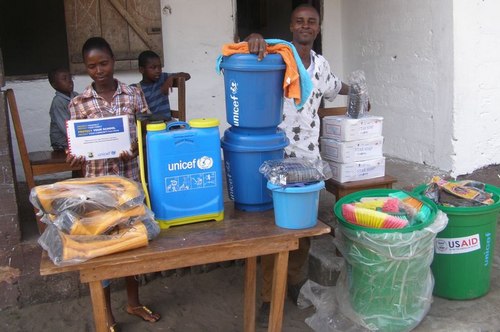L-R: The Registrar (Miss Annie Dayugar) and the Principal (Mr. Varney Gibson) posing behind the donated items