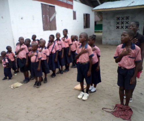 Students singing the National Anthem during devotion