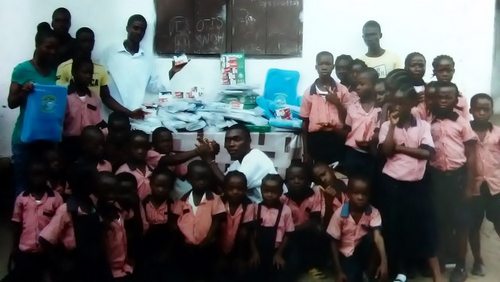 Kids and staff posting near the unpacked items