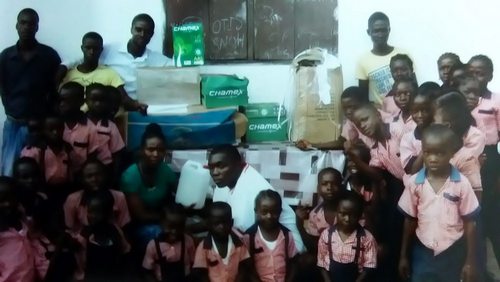 Students and staff posting near the still packed donated items