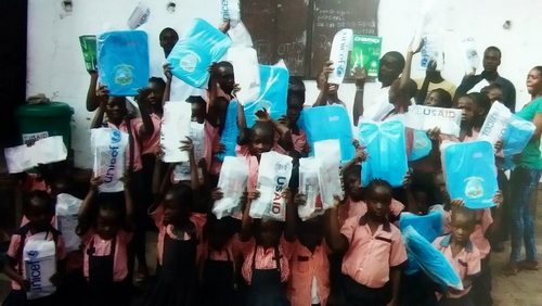 Students displaying their donated book bags and copybooks