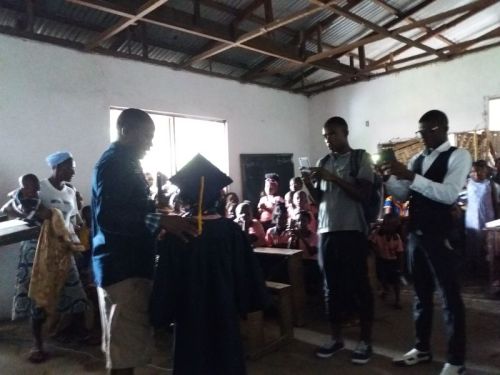 P-T.A chairman certificating one of the graduating kids, as parents take pictures