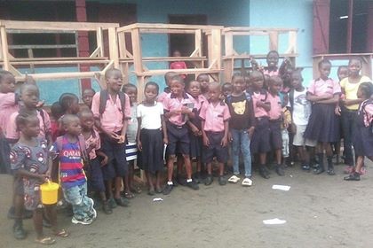 Some kids standing in front of the desks 2